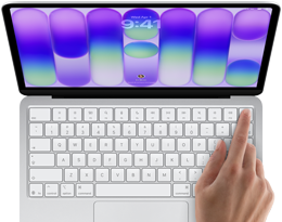 MacBook Neo na cor prateado, a mostrar o ecrã de início de sessão, o dedo de uma pessoa no sensor Touch ID no canto superior direito do teclado