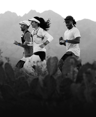 Três pessoas a correr numa zona montanhosa, todos a usar o Apple Watch Ultra 3