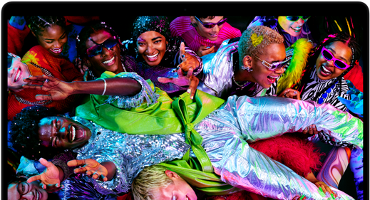 MacBook Pro com ecrã colorido a mostrar uma pessoa a fazer crowdsurfing numa festa, para apresentar as cores vibrantes do ecrã Liquid Retina XDR